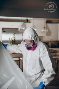 mold removal technician taping off a room in a house