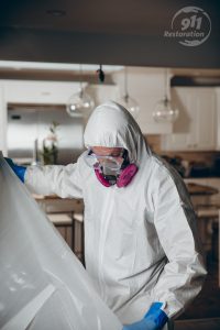 mold removal technician taping off a room in a house
