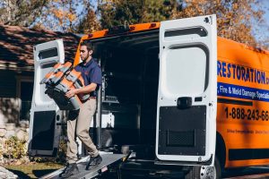 technician takes restoration equipment out of truck