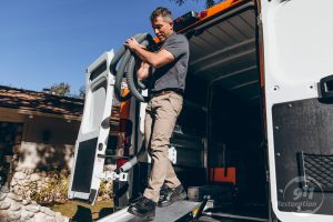 restoration technician carrying hose out of van